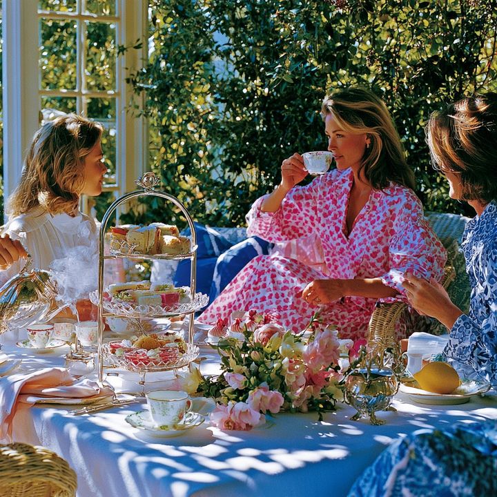 Women in colorful dresses enjoying a proper afternoon tea together